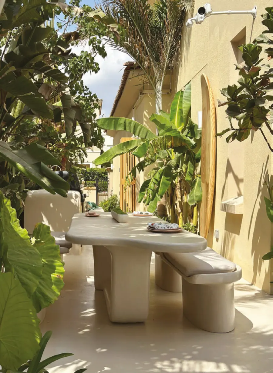 Sculpted outdoor dining table and benches in a tropical courtyard